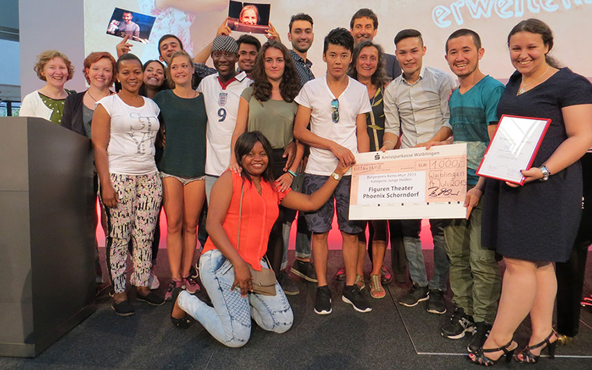 Mitglieder  des Figuren Theater Phoenix und des Ensemble LebensWelten halten die Urkunde und die Trophäe des Rems-Murr-Bürgerpreises in Händen.